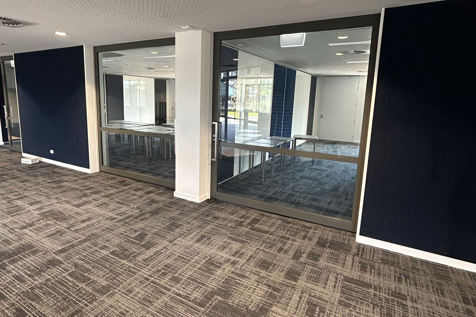 Glazed single cavity mounted acoustic sliding doors for flexible classrooms