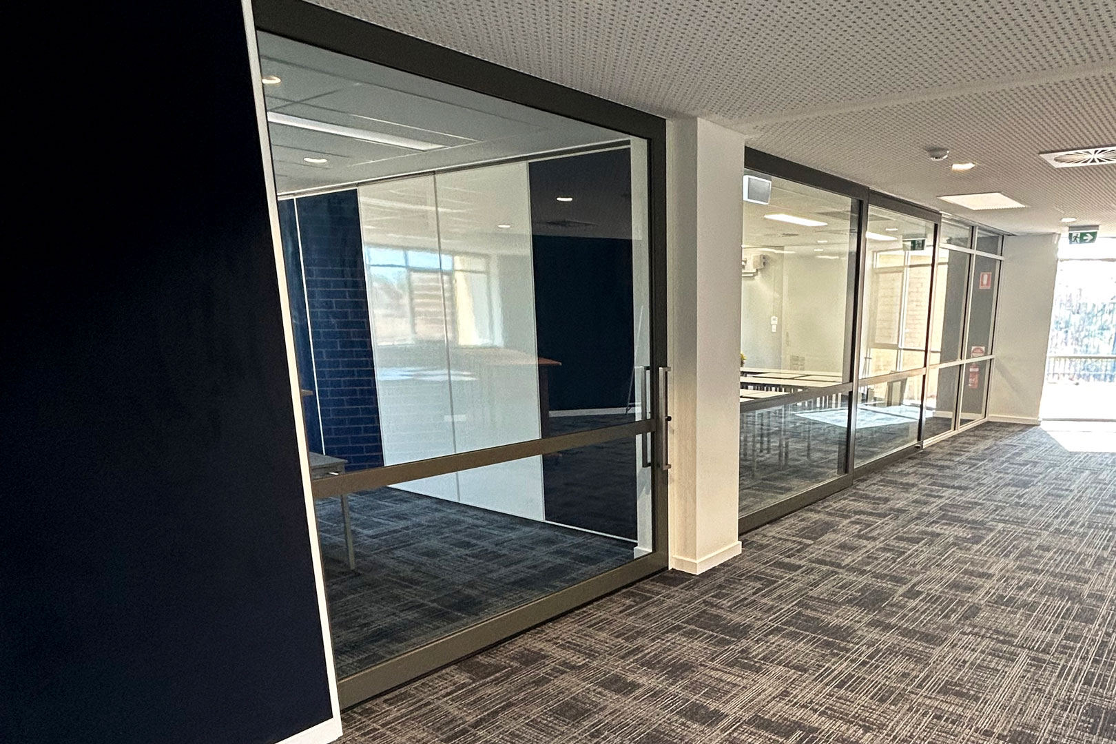 glazed acoustic slider and solid operable wall with whiteboards installed in a school