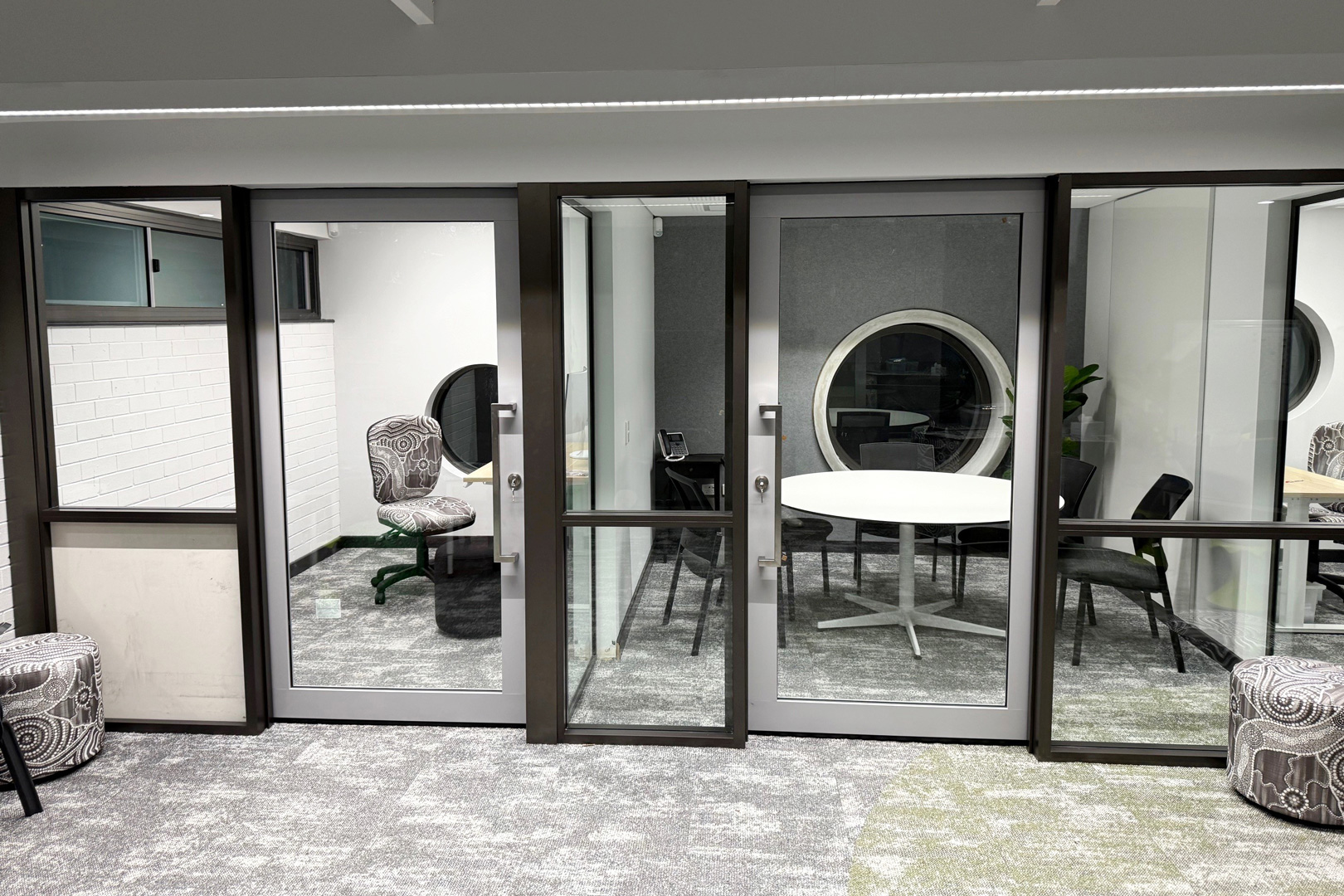 Glass recess mounted single clear view acoustic sliders installed in a school